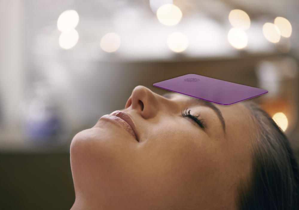 Application example: The Tesla Purple Energy Plate (7.0 x 11.4 cm) lying on the forehead of a person.